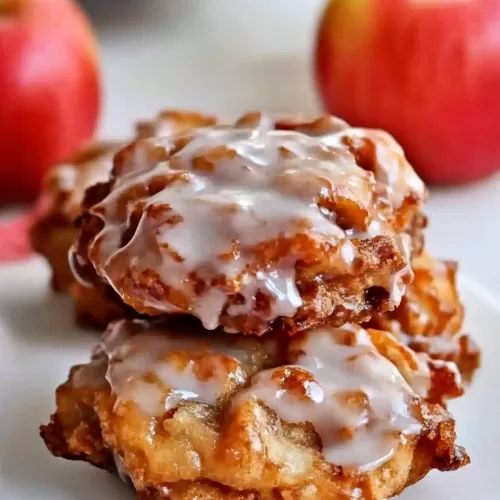 Golden-brown fried pastry drizzled with a shiny glaze, showcasing its crispy edges.