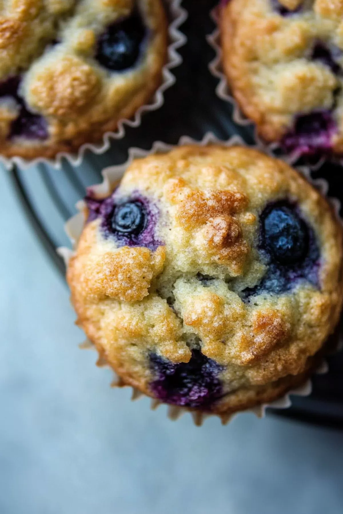 Close-up of a muffin showcasing fresh blueberries and a fluffy, moist texture.