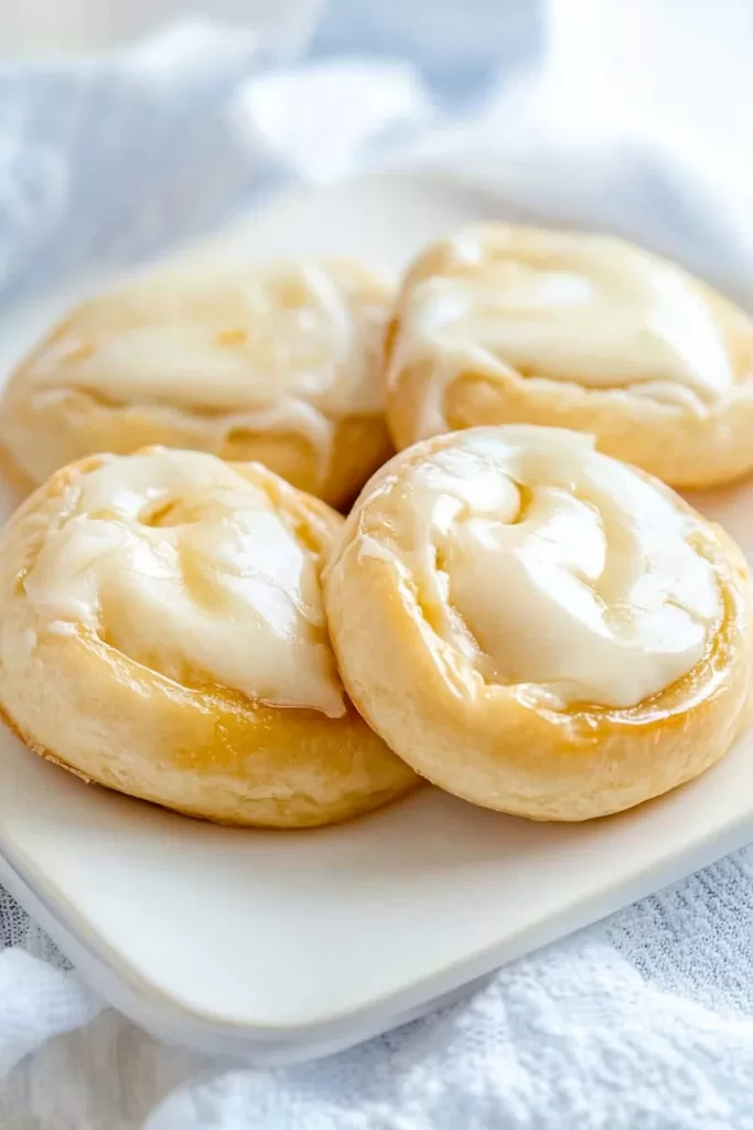 Golden, flaky pastries filled with creamy cheese, drizzled with a light glaze.