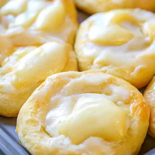 Close-up of freshly baked danishes with a smooth cheese filling and crisp edges.