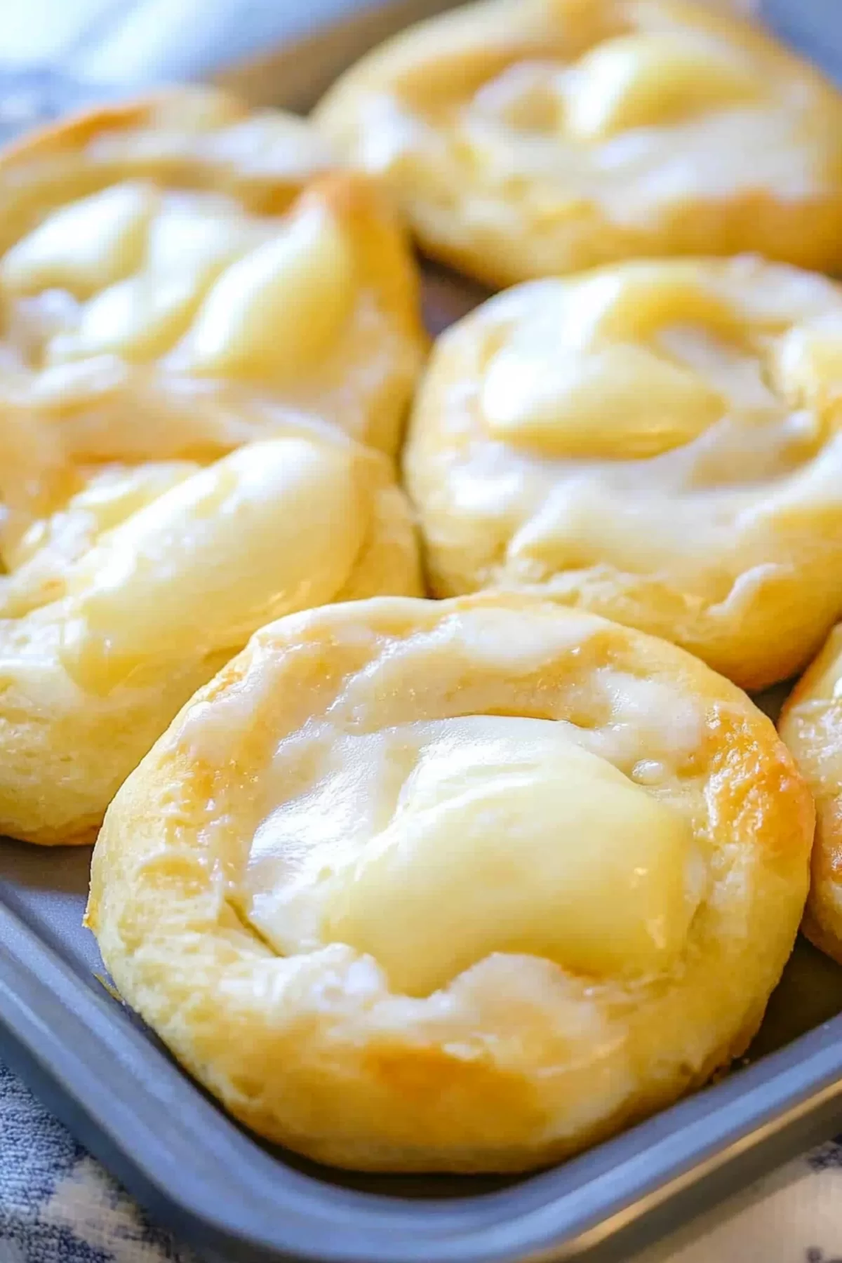 Close-up of freshly baked danishes with a smooth cheese filling and crisp edges.