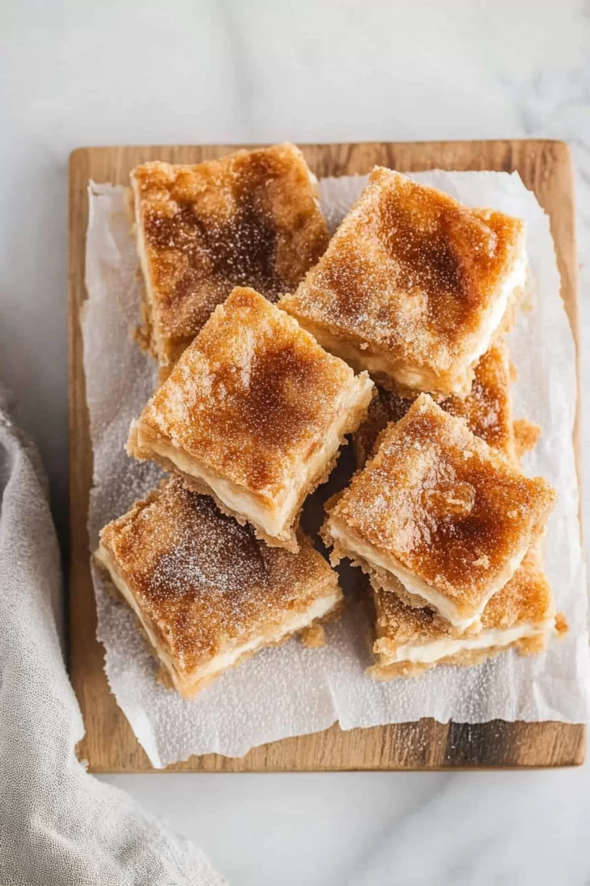 Crispy crescent layers filled with rich, velvety cheesecake, cut into squares.