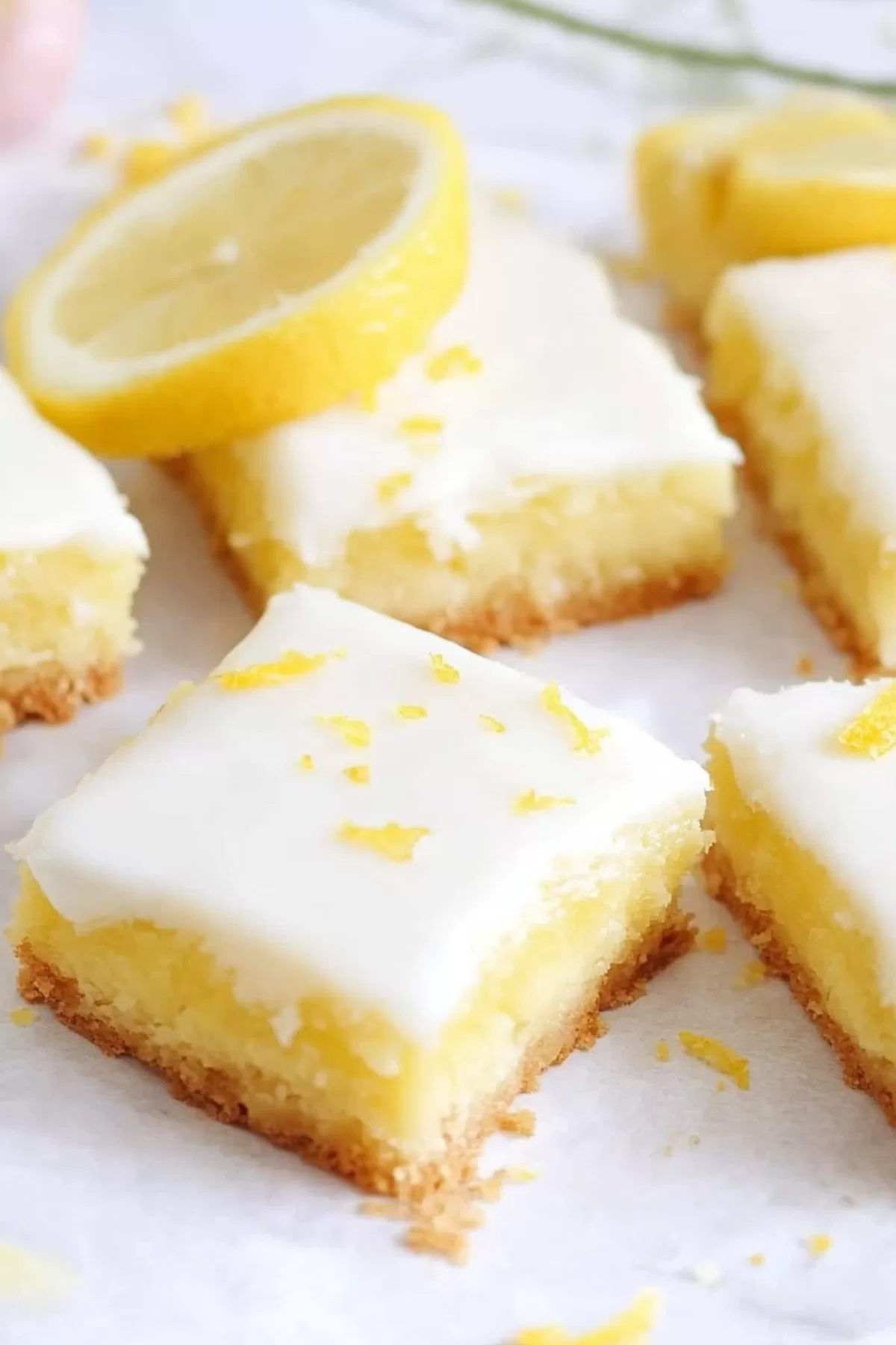 A stack of citrusy dessert squares dusted lightly with powdered sugar.