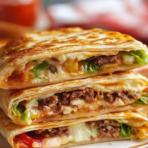 Golden folded tortilla stuffed with seasoned fillings, presented on a serving plate.