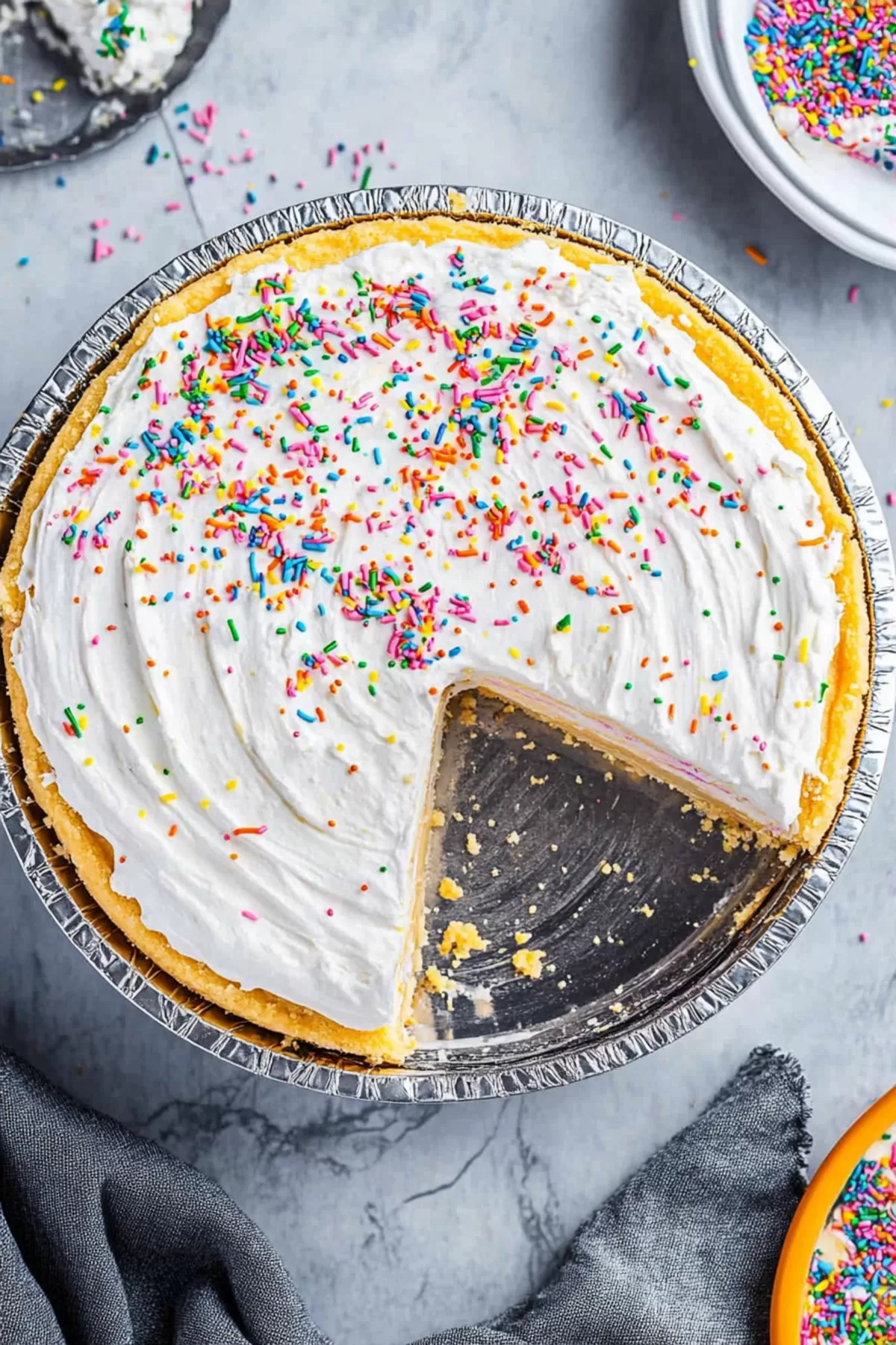 A colorful cheesecake topped with whipped cream and sprinkles.