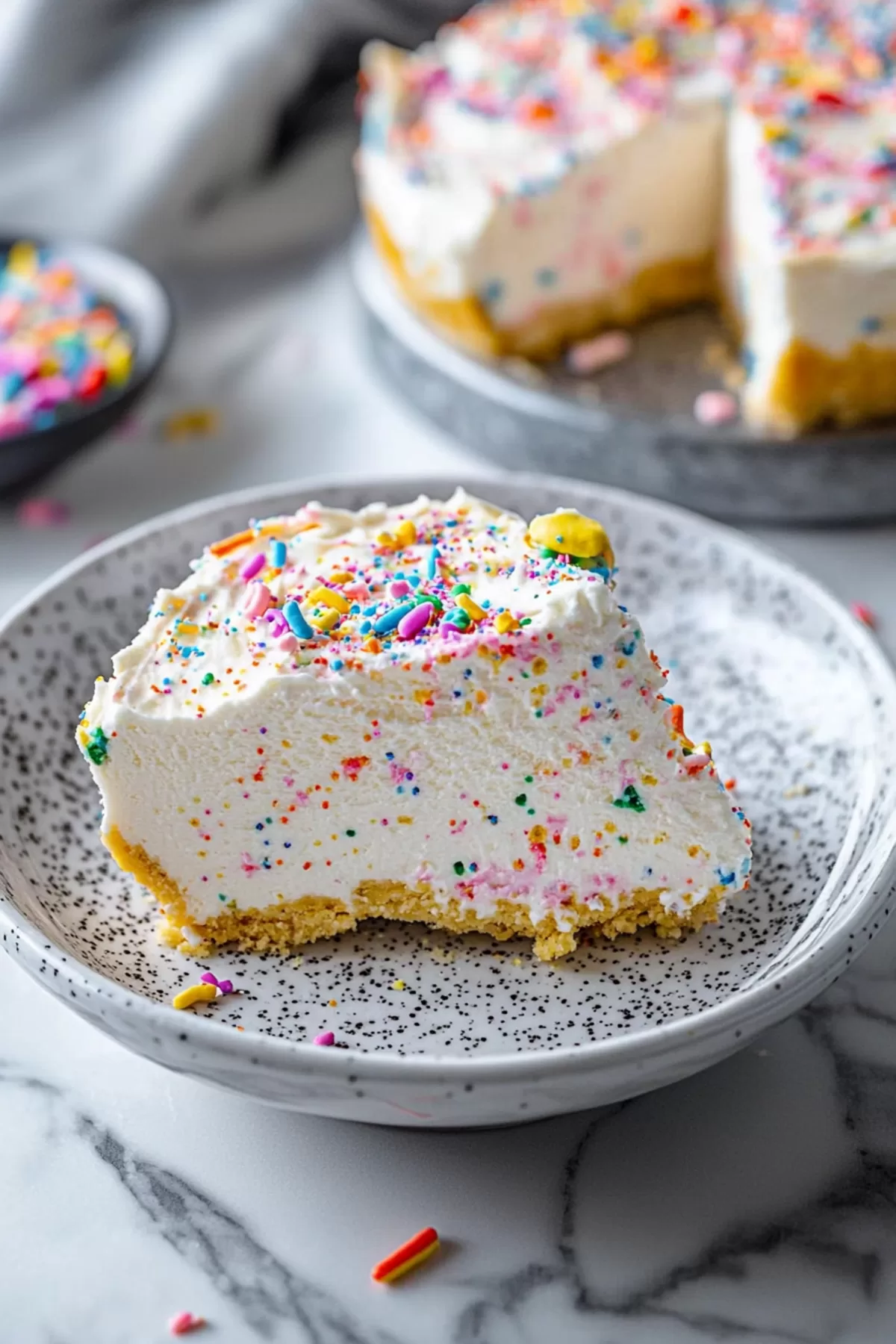 Bright and creamy dessert with a smooth texture and a sprinkle-covered crust.