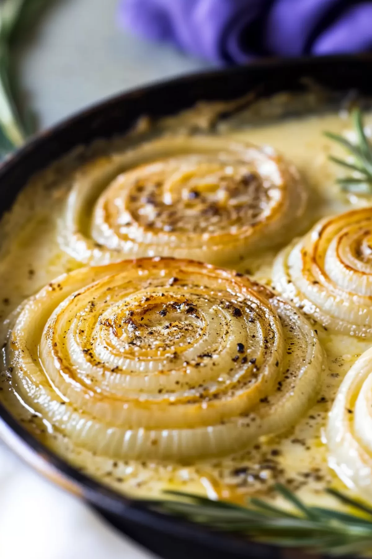 A serving dish filled with creamy, cheesy roasted onions, ready to serve.