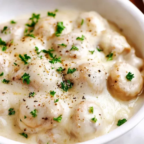 Deliciously tender mushrooms cooked in a creamy parmesan and garlic sauce, presented in a white skillet.