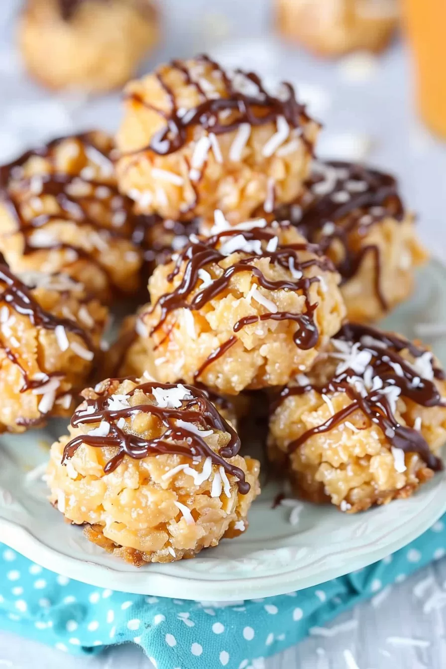 A white serving plate showcasing a cluster of caramel-dipped coconut macaroons with a glossy chocolate finish.