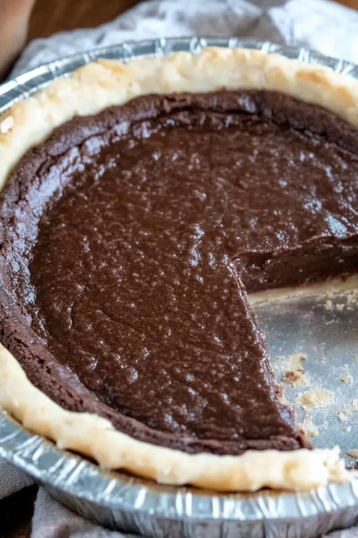 A chocolate cream pie with a single slice removed, revealing its smooth and creamy filling.