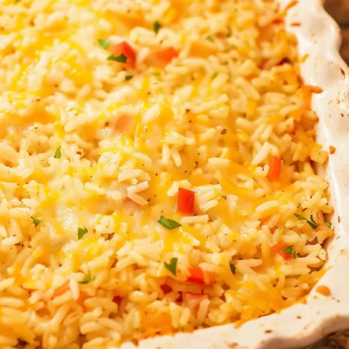 A serving of cheesy Pepper Jack rice bake in a rustic bowl, highlighting the vibrant red and green pepper bits.