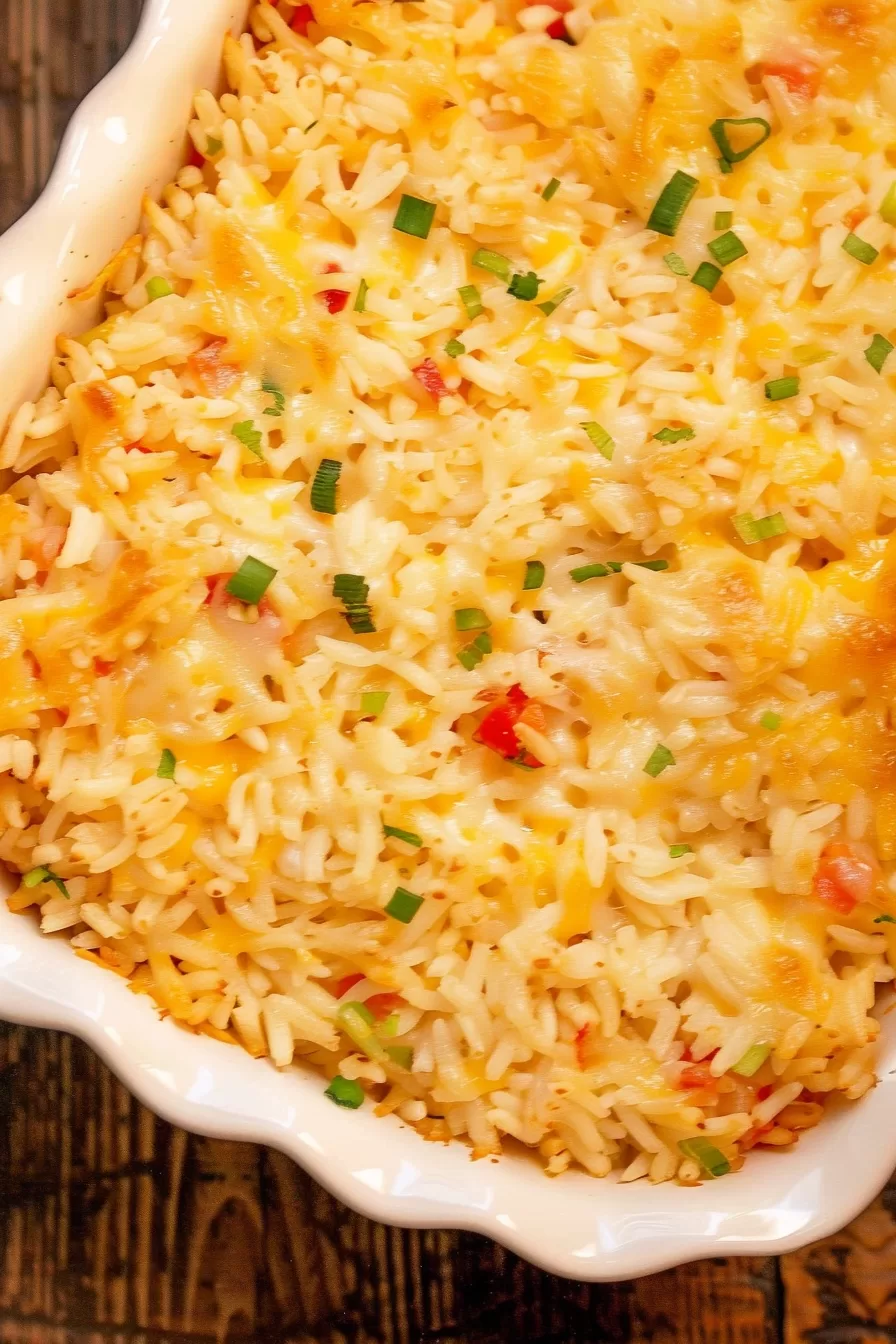 Top-down shot of a bubbly, golden-brown Pepper Jack rice bake fresh out of the oven in a white casserole dish.