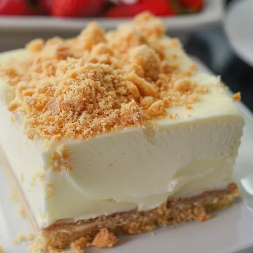 A slice of chilled cheesecake featuring a light, airy texture and a crunchy crumb topping.