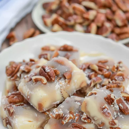 Sweet and glossy nut candies topped with chopped pecans, ready to serve.