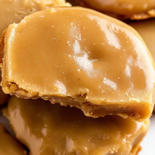 Close-up of golden brown maple bars with a smooth maple glaze, stacked on a plate.