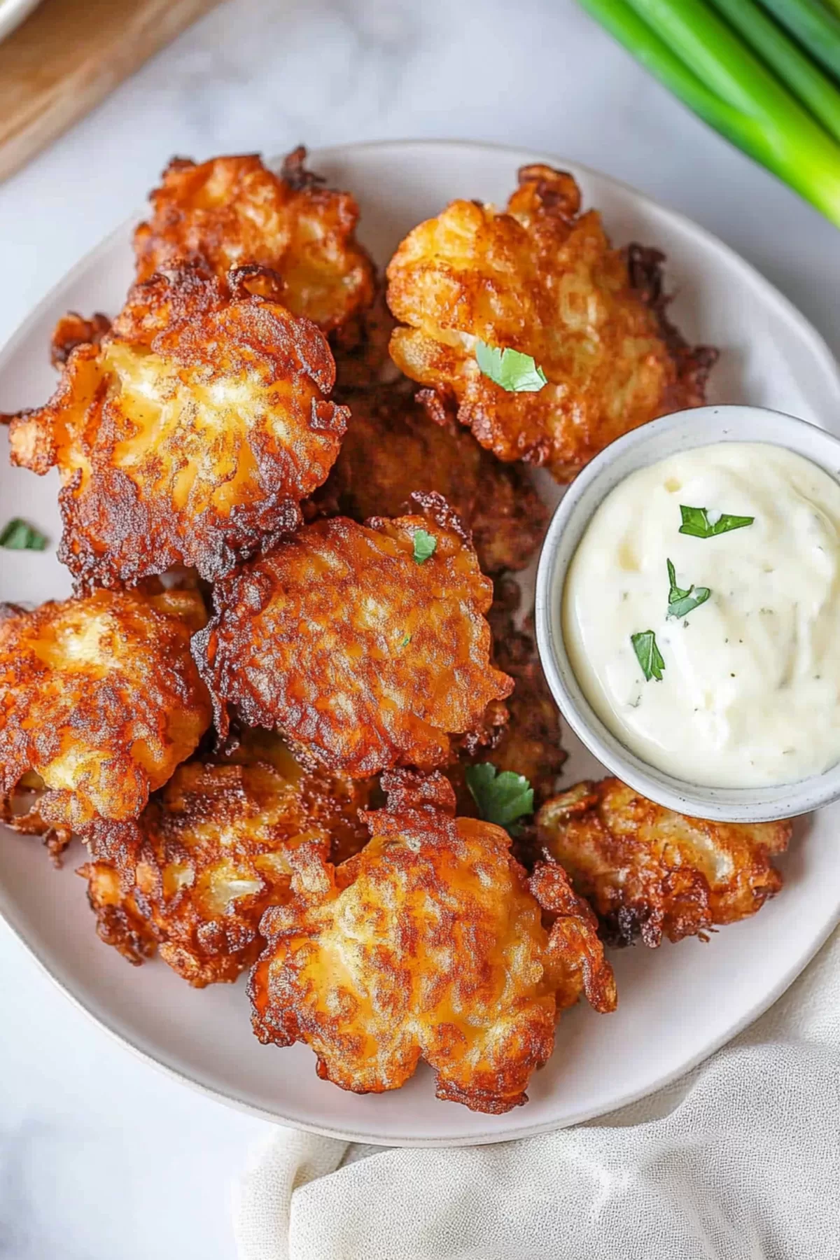 Crispy, savory fritters paired with a dollop of creamy dipping sauce.