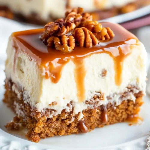 A close-up of a piece of cake topped with a luscious caramel glaze and nuts.