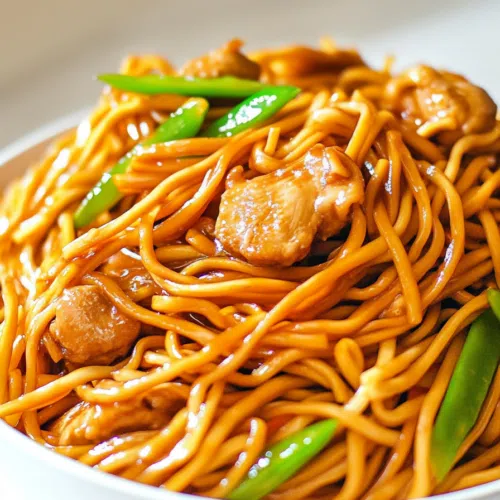 A steaming bowl of chicken chow mein, topped with sesame seeds and fresh scallions.