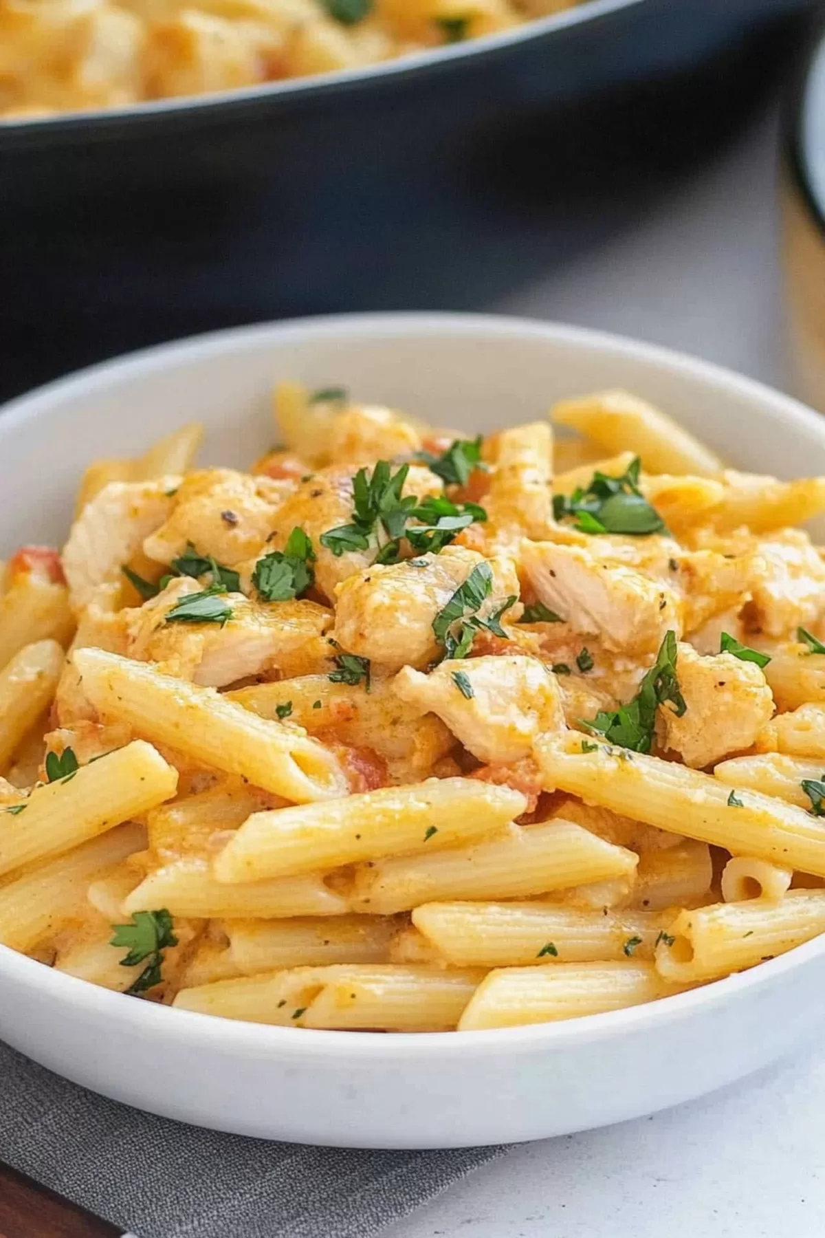 Warm and creamy penne with shredded chicken and crispy bacon for a flavorful meal.