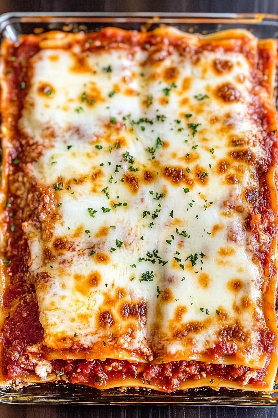 A baking dish filled with layers of cheesy lasagna, topped with a golden, bubbly crust.