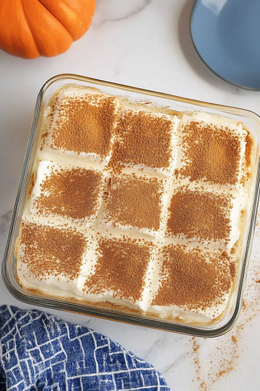Top-down view of a serving of no-bake pumpkin delight, garnished with a dollop of whipped cream and a dash of nutmeg.