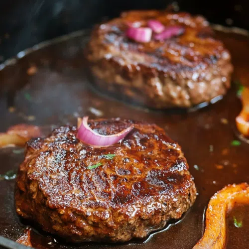 Close-up of homemade Salisbury steak with caramelized onions and a savory sauce.