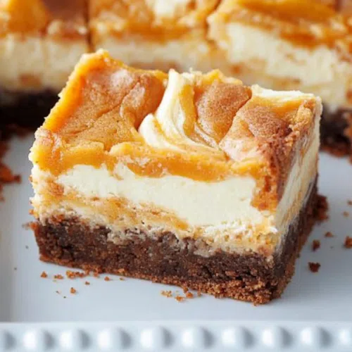 Golden-brown dessert bars with a creamy, swirled topping.