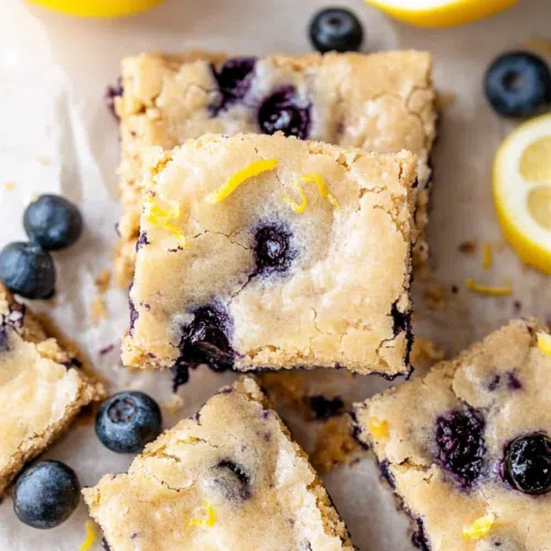 A close-up of blueberry blondies with a golden crust and juicy blueberries.