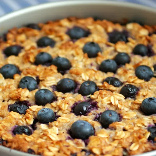 A whole coffee cake with blueberries and cream cheese layers visible from the side