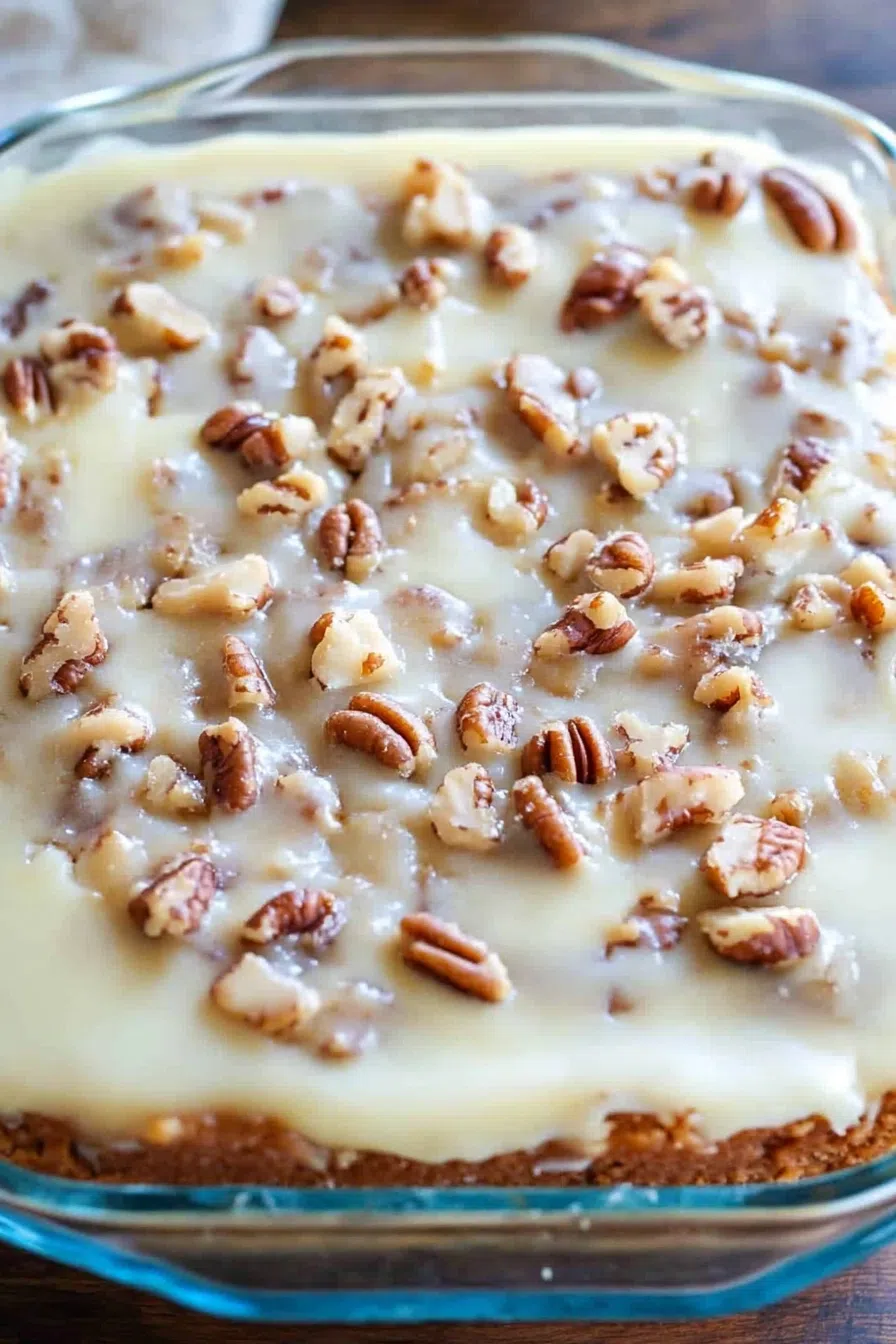 A whole cake with a golden-brown top and pecan garnish.
