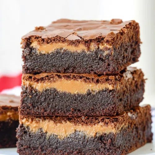 Close-up of gooey brownies revealing a rich peanut butter filling.