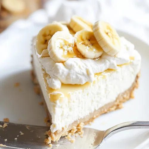 Chilled dessert slice with a creamy filling and whipped topping, served on a ceramic plate.