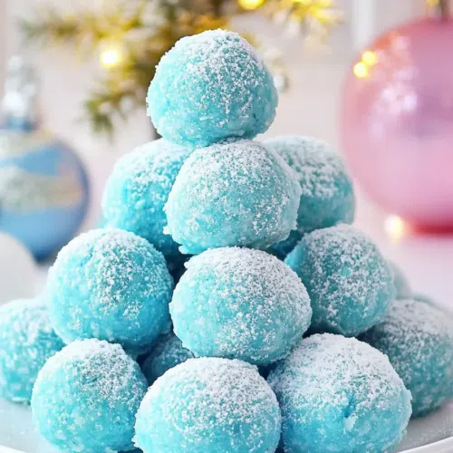 A plate of festive truffles with a smooth, glossy finish and sprinkles of blue decoration.