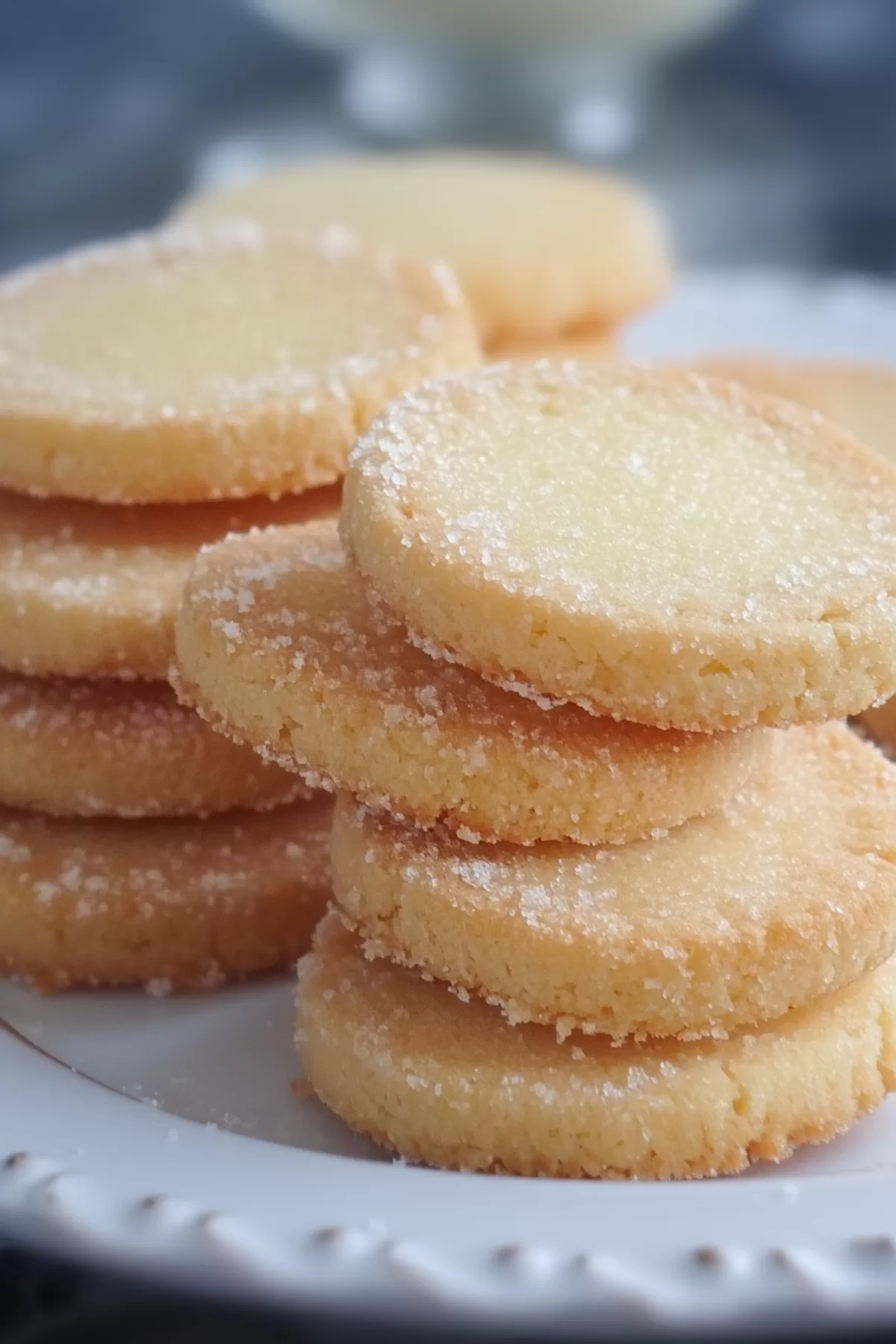 A pile of buttery cookies with a glistening sugar finish, showcasing their crumbly texture.