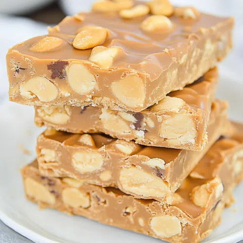 Close-up of chewy caramel bars coated in salted peanuts.