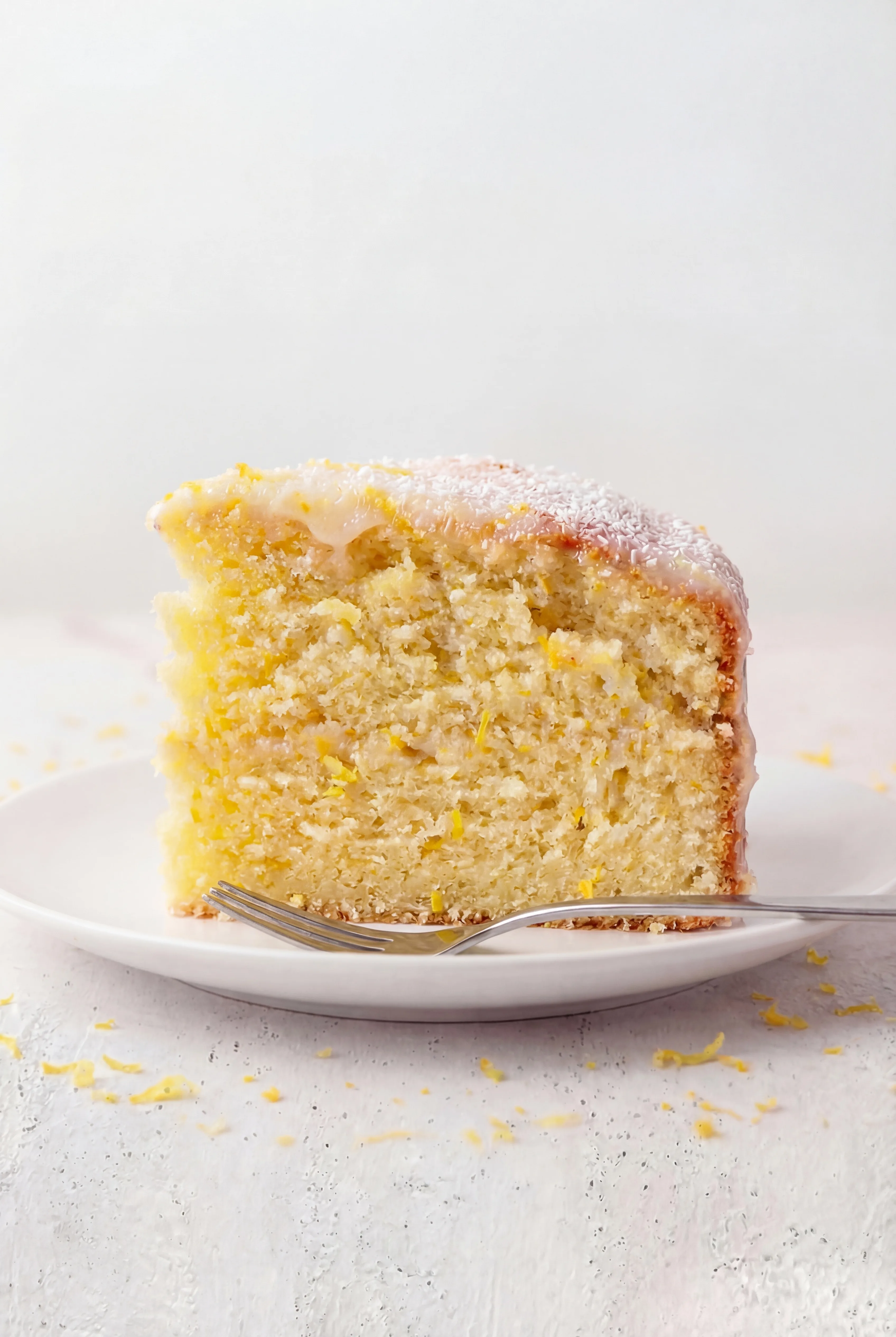 slice of Limoncello Ricotta Cake showing tender texture with lemon zest and light glaze