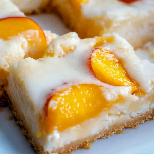 A batch of homemade bars with a crumbly base and luscious peach topping.