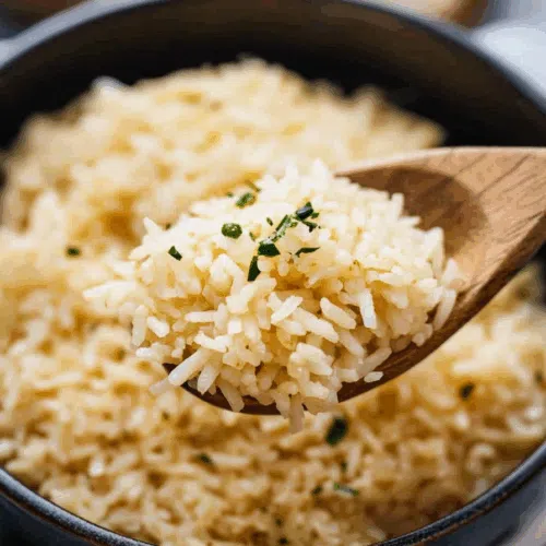 Spoonful of warm, savory rice lifted from a casserole dish.
