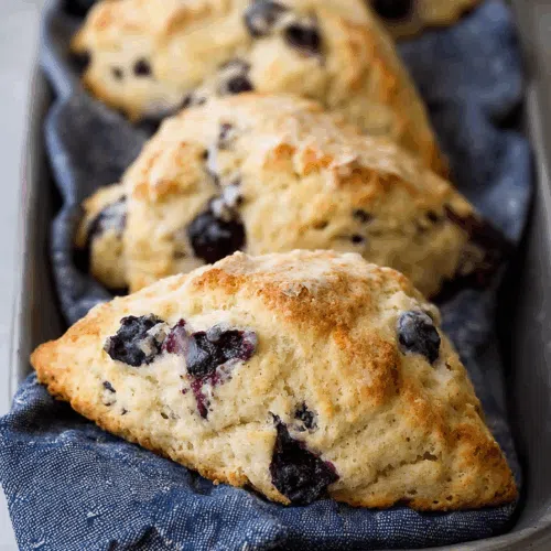Freshly baked treats cooling on a cloth napkin-lined tray.