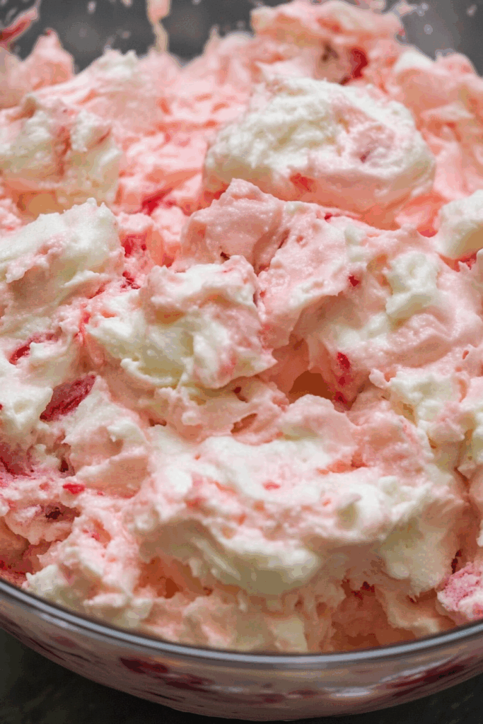 Close-up of airy, fruit-studded fluff with swirls of red and white.