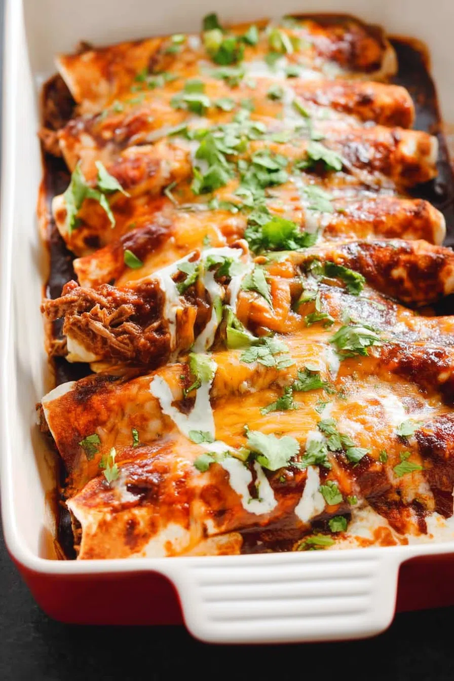 Baked enchiladas topped with melted cheese and chopped green onions in a casserole dish.