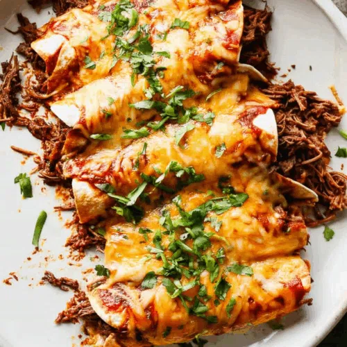 Overhead view of a casserole pan with golden, saucy rolled tortillas.