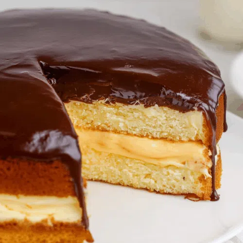Close-up of a layered cake with custard center and smooth ganache.