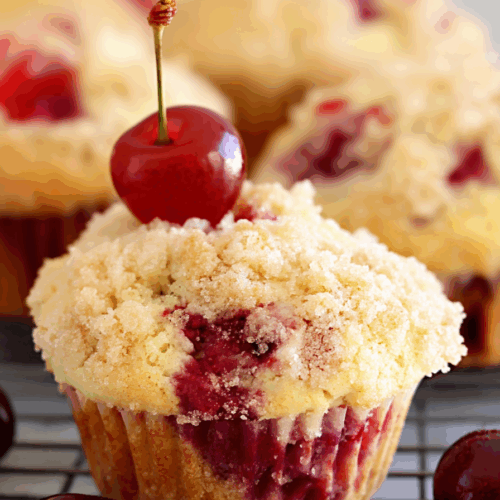 Close-up of a golden muffin with a soft, fruit-filled center.