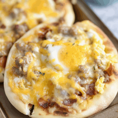 Close-up of a golden crust topped with melted cheese, eggs, and crispy bacon.
