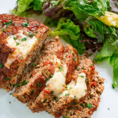 Close-up of a juicy interior revealing layers of seasoned meat and gooey cheese.