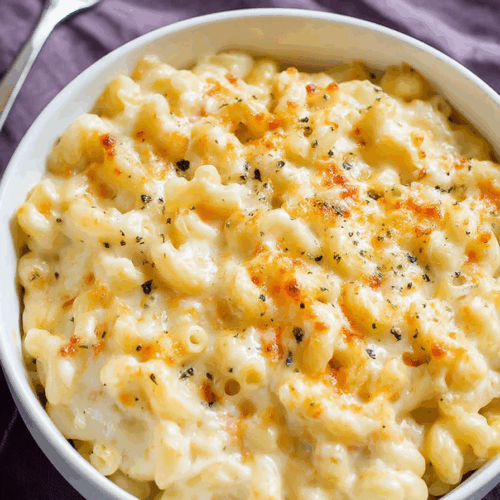 Golden-brown pasta casserole with crispy topping in a white bowl.