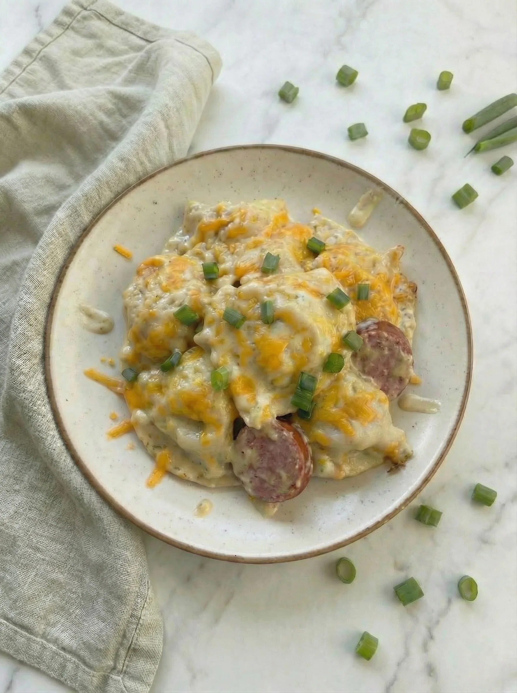 Crockpot Pierogi Kielbasa Casserole served on a plate with creamy sauce and sliced kielbasa