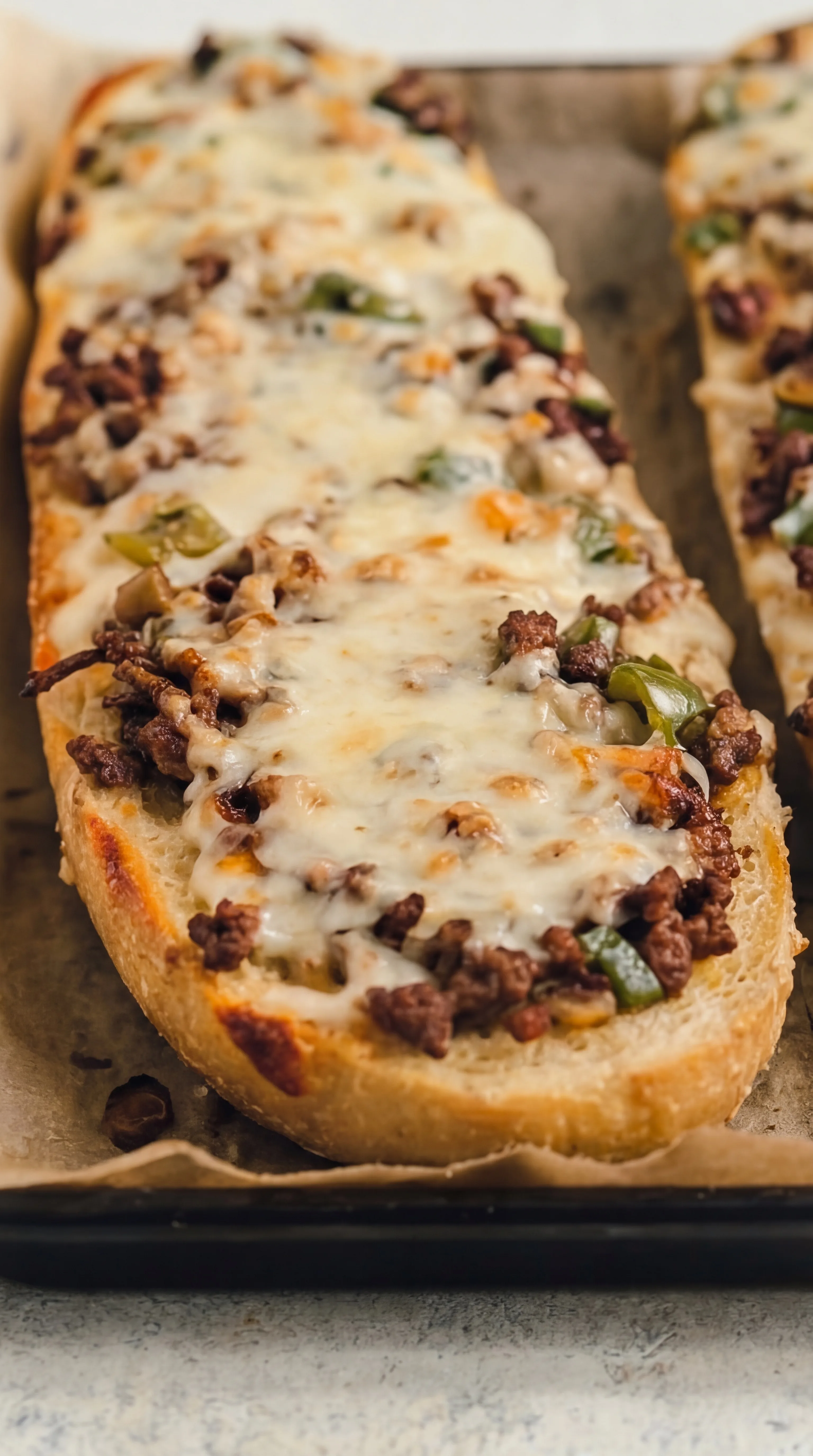 baked cheesesteak cheesy bread with melted golden cheese on toasted bread halves