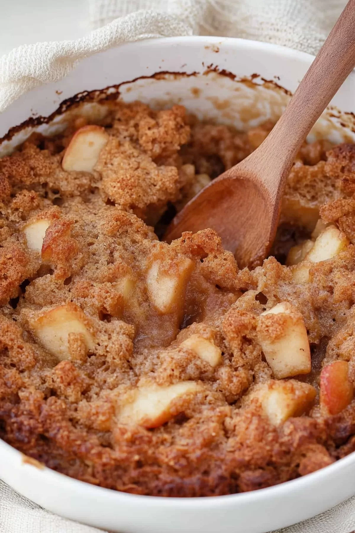 Close-up of a warm and crumbly Apple Brown Betty dessert served in a white dish.